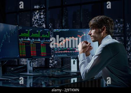 business man looking at the charts of the stock market of cryptocurrencies on the PC screen. Stock Photo