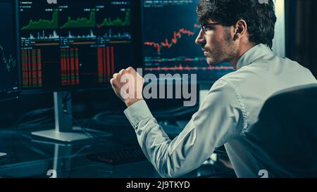 young investor looking hopefully at the charts of the cryptocurrency stock market. Stock Photo