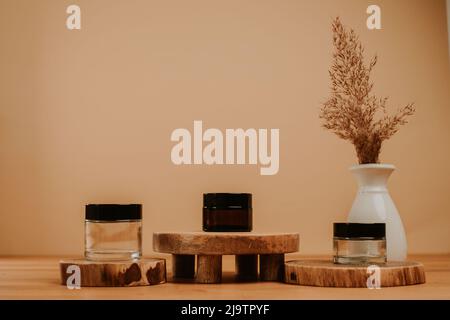 Jar set on wooden stage and brown natural leaf in vase Stock Photo