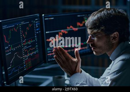 businessman looking at computer monitors with stock market data . Stock Photo