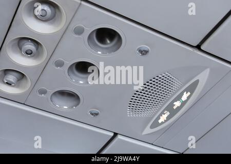 Overhead console panel inside the a passenger aircraft, showing air conditioner button and lighting switch and flight attendant call buttons Stock Photo
