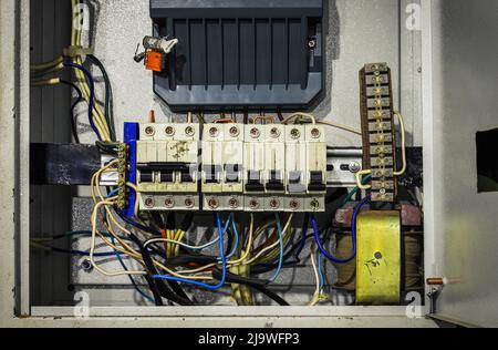 Cable chaos in electric control panel close-up. Tangled wires. Circuit breakers Stock Photo