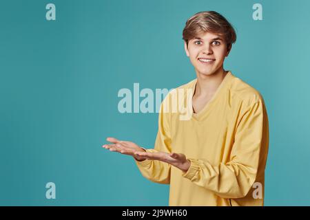 man in casual yellow clothes pointing to the side Stock Photo