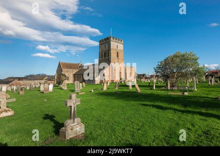 Bamburgh church, view of the 12th century St Aidan's Church and its scenic churchyard in the Northumberland coastal village of Bamburgh, England, UK Stock Photo