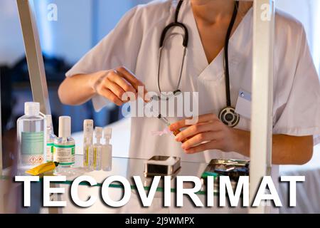 Tecovirimat. Nurse. Medical. Text written on an unfocused background and virus design of a nurse with an injection to give a vaccine. Virus Stock Photo