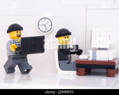 Tambov, Russian Federation - May 24, 2022 Two Lego minifigure robbers hacking computers. Stock Photo