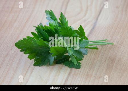 Bunch of parsley on a wooden board close-up. Fresh herbs for cooking. Stock Photo