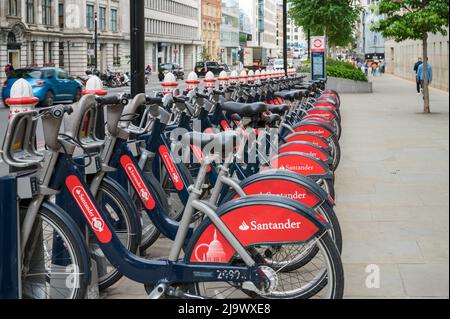 A line of Santander sponsored public hire bicycles parked in a docking station on Farringdon Street, London, England, UK. Stock Photo