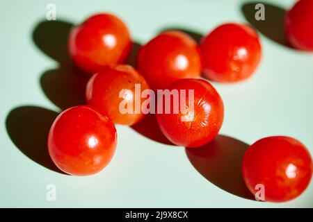 Cherry tomatoes on light green background Stock Photo