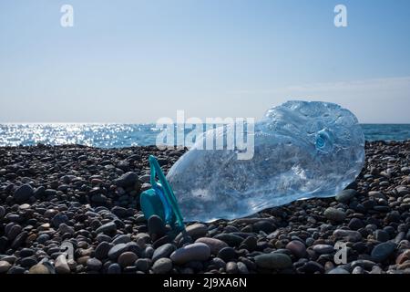 Empty used plastic bottle on beach background. Environmental pollution concept Stock Photo