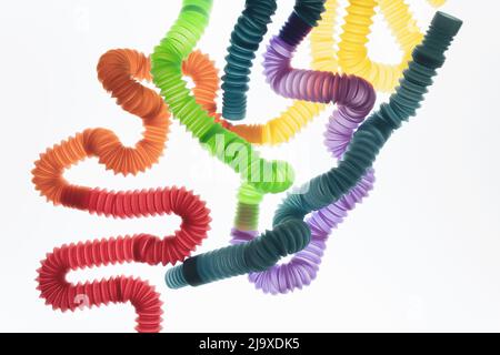 Trendy kids toys — colorful pop tubes on white background. Set of different forms and colors corrugated pipe. Stock Photo