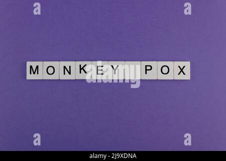 MONKEY POX. Word written on square wooden tiles on purple background. Viral disease. Medical and health concept. Stock Photo