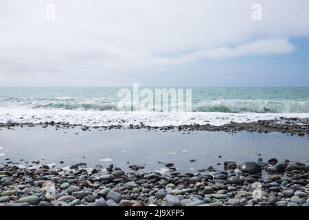 Sea stones background in the seaside on a beach. A close up view of rounded polished stones Stock Photo