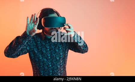 Indoor studio shot of a caucasian bearded entrepreneur man trying out virtual reality goggle set for the first time. Innovation and technology concept. High quality photo Stock Photo