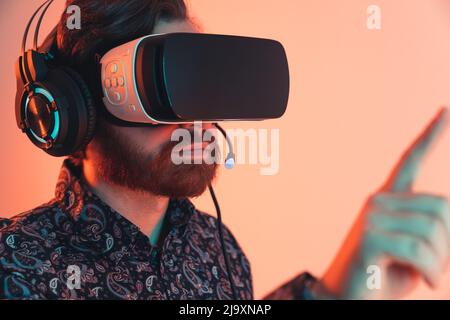 Closeup studio portrait of a professional VR glasses and headphones used by a caucasian bearded man. Leisure time activity. High quality photo Stock Photo