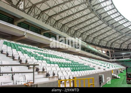 Empty seats in modern football stadium with roof. Green and white tribunes. Seats of tribune on sport stadium Stock Photo