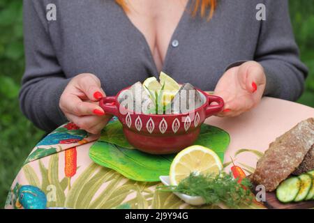 Woman eating canned mackerel Stock Photo