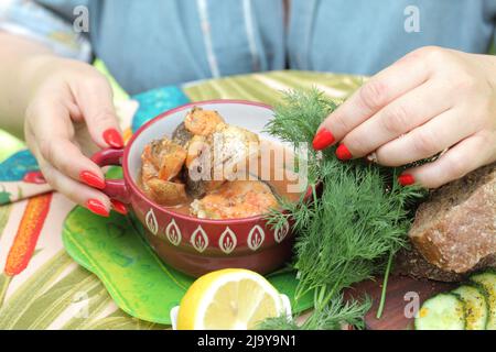 Woman eating pike in tomato with black bread in tomato pike Stock Photo
