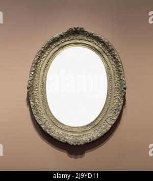 Old-fashioned oval frame on wall. Stock Photo