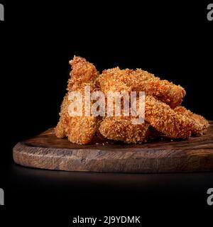 set deep-fried chicken legs set, chicken nuggets on a wooden tray, isolated on black. Stock Photo
