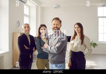 We stand together. a smiling group of coworkers standing in an office ...