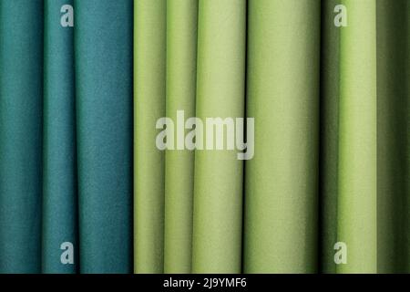 Folded vertical curtains lime and blue-green color curtains as hotel interior Stock Photo