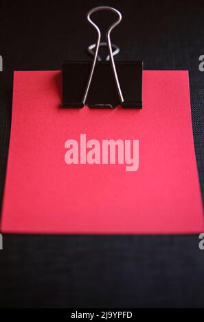 Piece of red paper in a bulldog clip Stock Photo