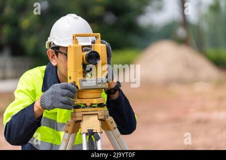 Surveyor Civil Engineer using equipment theodolite or total positioning station on the construction site. Stock Photo