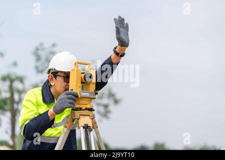 Surveyor Civil Engineer hand signal with equipment on the construction site. Stock Photo