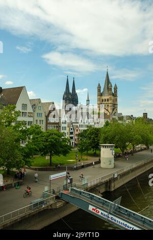 Cologne, Germany - May 17, 2022 : Panoramic view of the cathedral Saint Martin, the Dom and people walking next to the river Rhine of Cologne