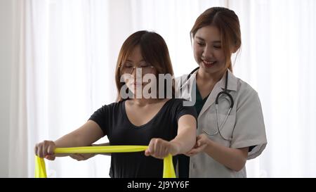 Patient doing some special exercises under supervision of physiotherapist. Stock Photo