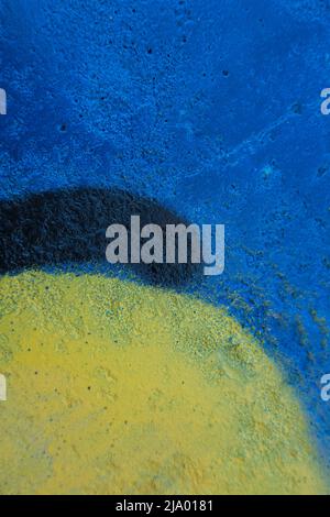 Blue and yellow painted old grungy cracked weathered concrete wall surface texture background Stock Photo