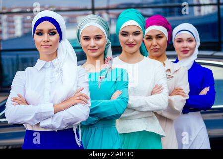 group of five strong beautiful and young Muslim business women fashion look stylish long dress and the turban covers the head standing powerful Stock Photo