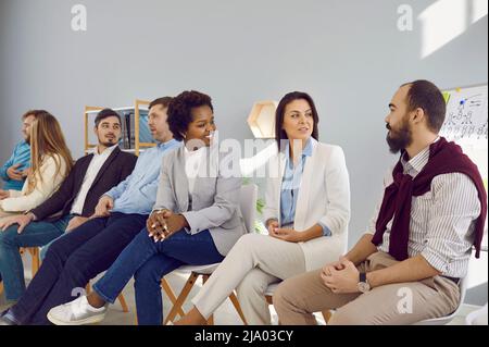 Different groups of people communicate with each other during business seminar or training. Stock Photo