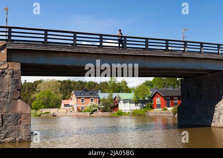 Porvoo, Finland - June 12, 2015: A man walks the Old Bridge of Porvoo on a sunny day Stock Photo
