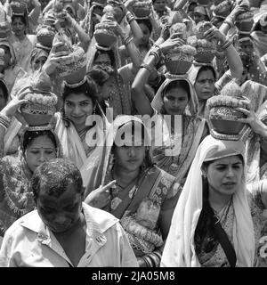 Delhi, India April 03 2022 - Women with Kalash on head during Jagannath Temple Mangal Kalash Yatra, Indian Hindu devotees carry earthen pots containin Stock Photo