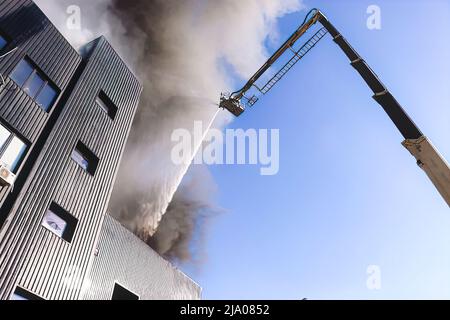 Firefighters on the stairs extinguish a big fire. Firefighters at house fire Stock Photo