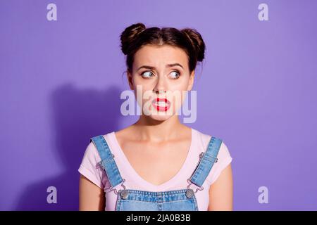 Portrait of minded doubtful person grin teeth look interested empty space isolated on purple color background