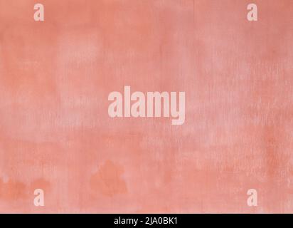 Plastered, weathered and painted pinkish, reddish peach colored concrete wall. Abstract high resolution full frame textured background. Copy space. Stock Photo
