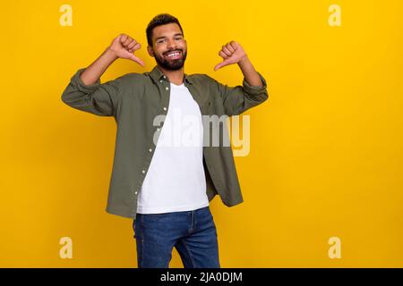 Photo of pretty excited guy dressed green shirt pointing two thumbs himself isolated yellow color background Stock Photo