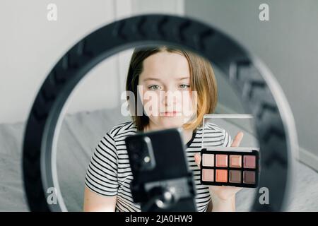 Teen girl blogger recording video for beauty blog. Blogging, videoblog, makeup concept. Stock Photo