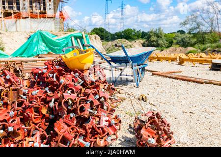 View on heap of disassembled steel scaffolding joint on construction site. Stock Photo
