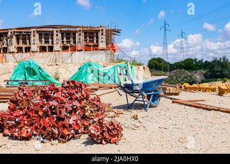 View on heap of disassembled steel scaffolding joint on construction site. Stock Photo