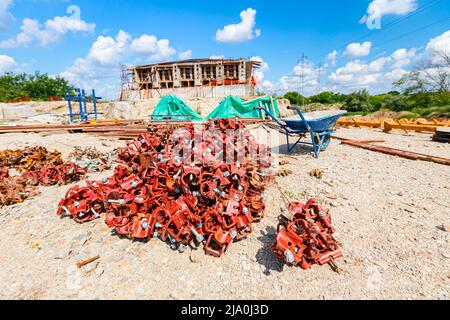 View on heap of disassembled steel scaffolding joint on construction site. Stock Photo