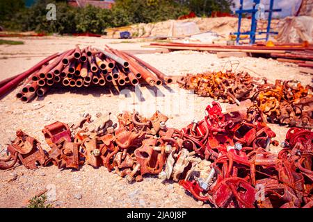 View on heap of disassembled steel scaffolding joint on construction site. Stock Photo