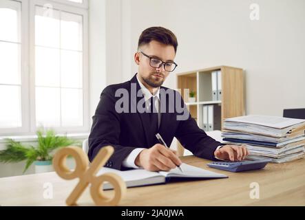 Business accountant at office desk calculating corporate tax and interest rate percent Stock Photo