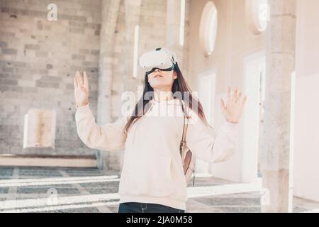 Woman wearing vr headset in european street, virtual travel concept Stock Photo