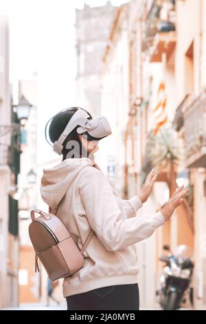 Woman wearing vr headset in european street, virtual travel concept Stock Photo