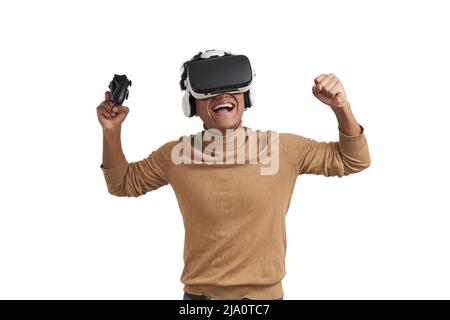 Young peruvian man playing games with joystick and vr headset, isolated. Stock Photo