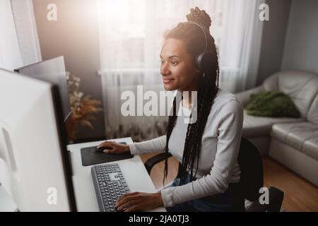 Portrait of smiled beautiful woman developer working indoor, stylish young female using computer Stock Photo